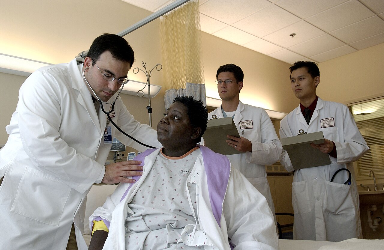 A doctor listening to a patient's chest with a stethoscope.