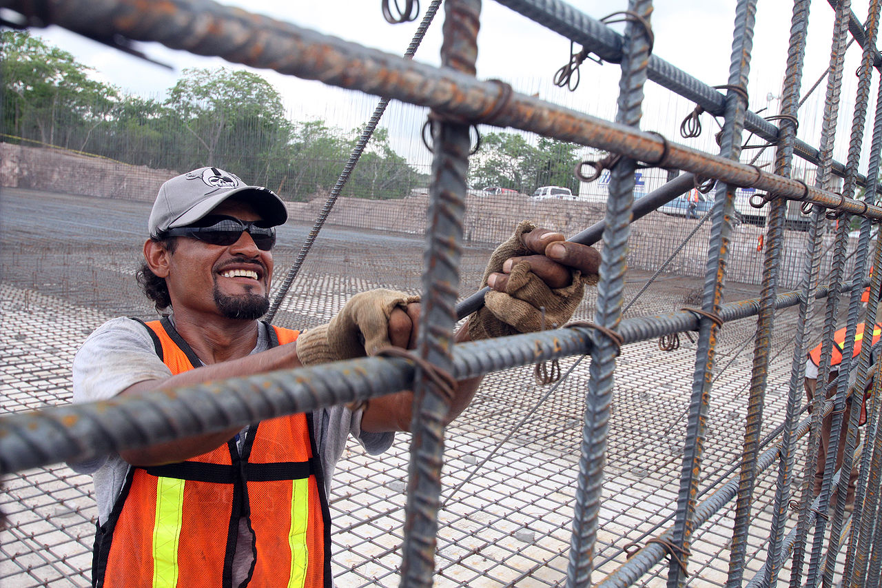 A construction worker tying steel reinforcing bar on a building site.