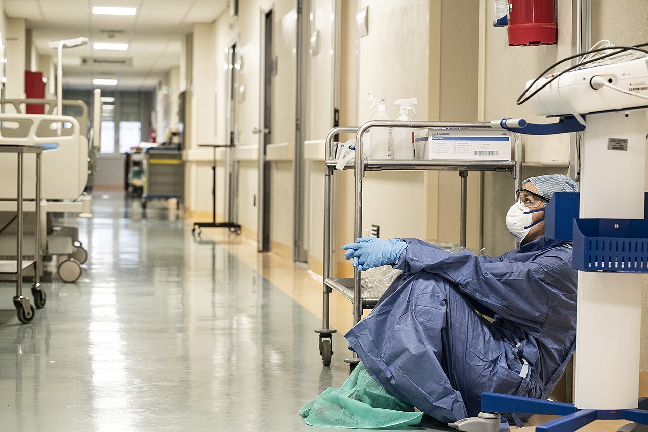 A healthcare worker in protective equipment on a hospital ward.