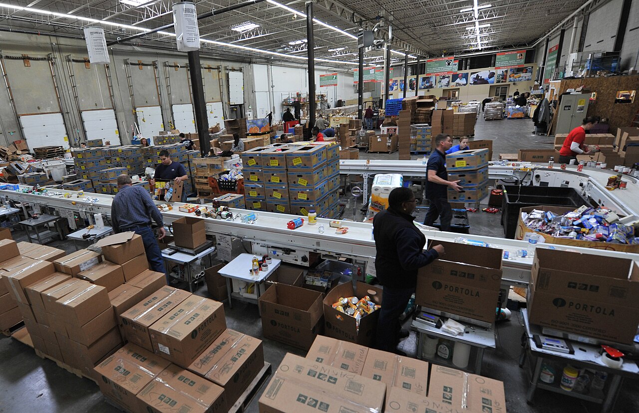 Volunteers sorting and packing food at a community food bank.